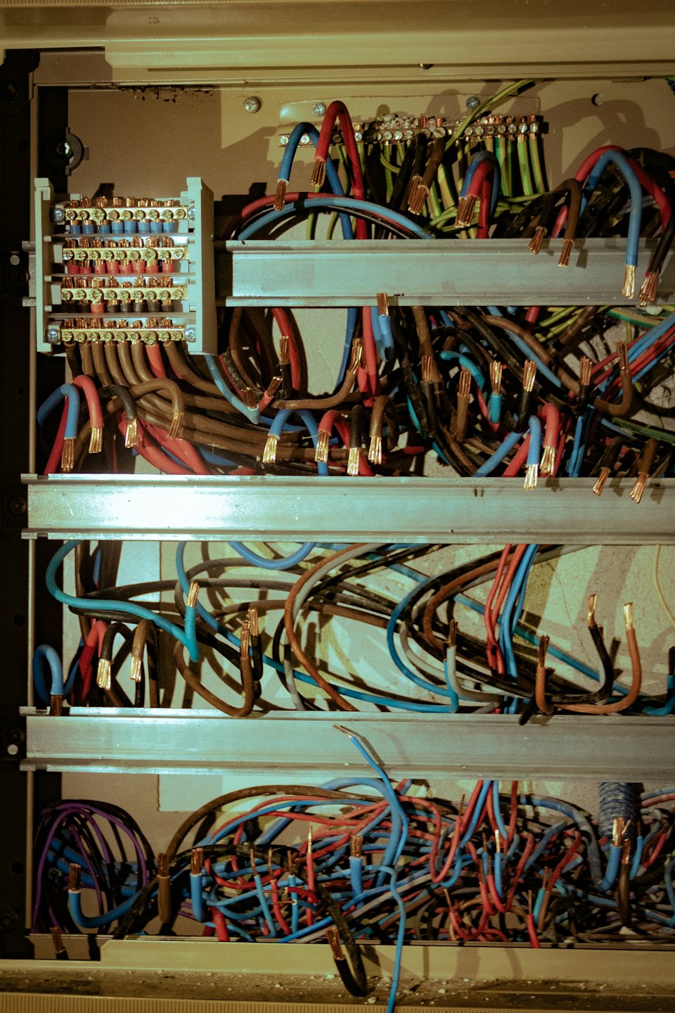 Fili elettrici multicolori collegati a morsettiere all'interno di un quadro.